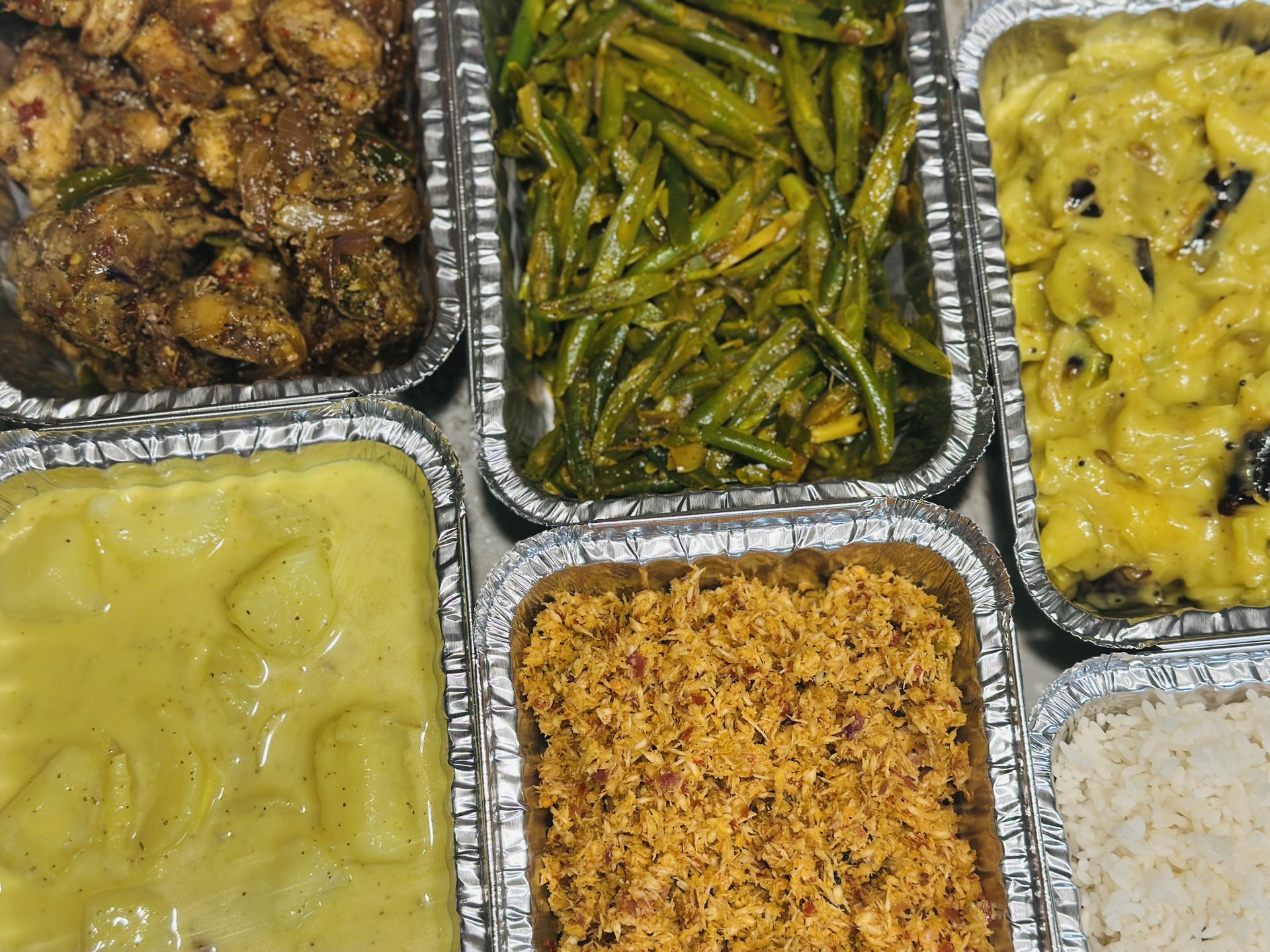 Multiple catering trays of Sri Lankan dishes for an event