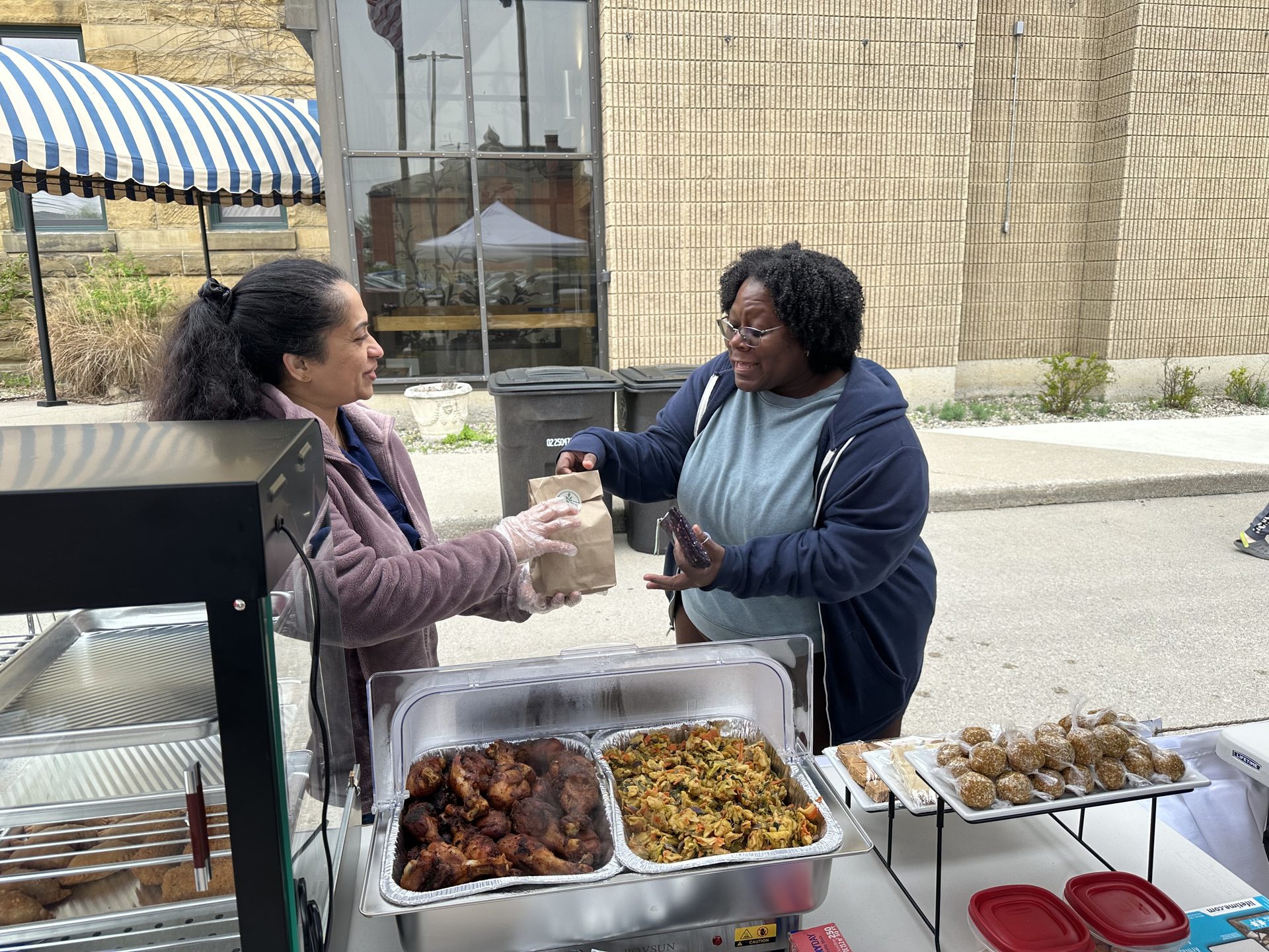 Sarana serving a customer at The Flavor Patch booth at the YLNI Farmers Market